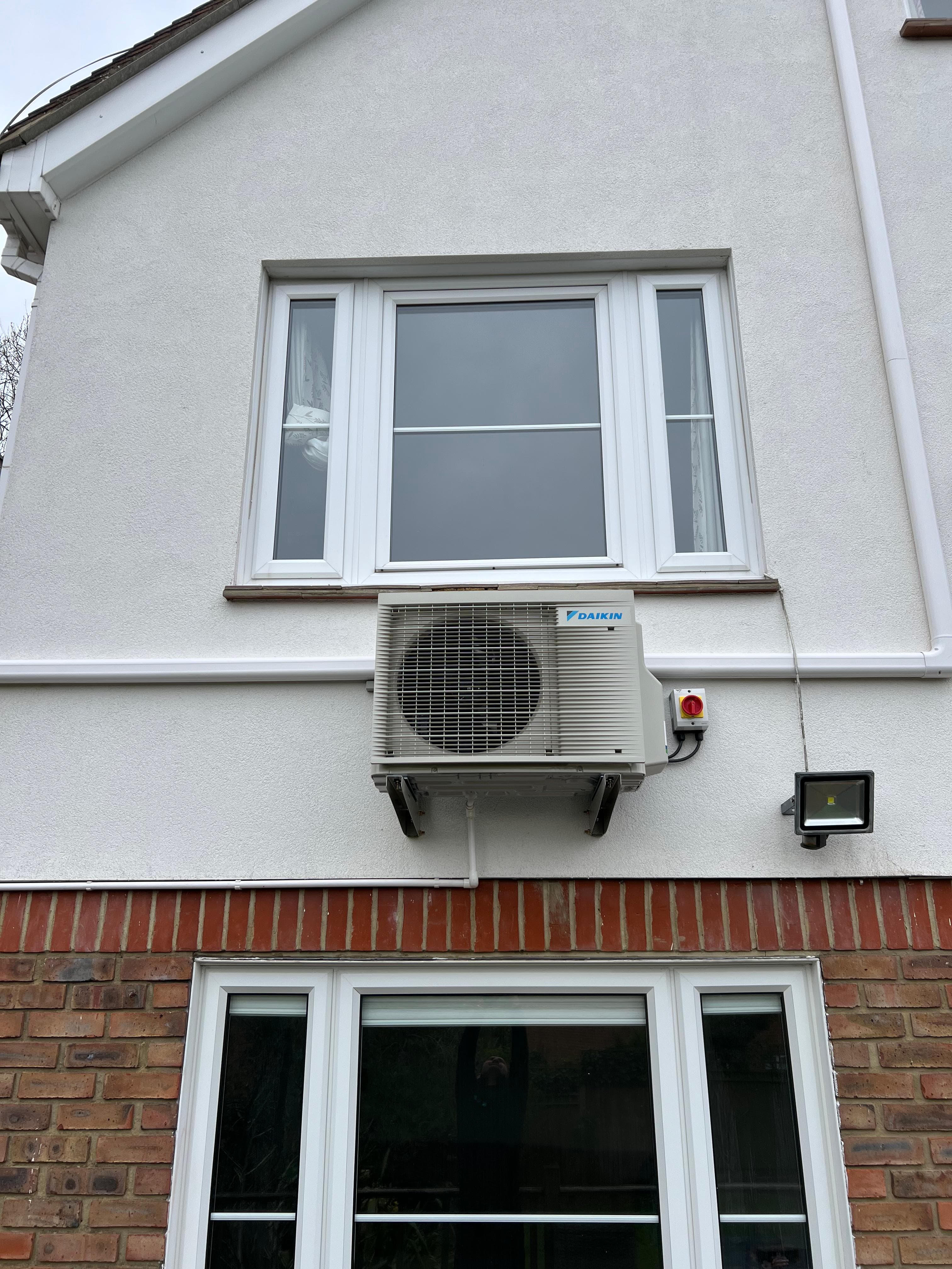 Outdoor condenser unit on a wall bracket - side elevation