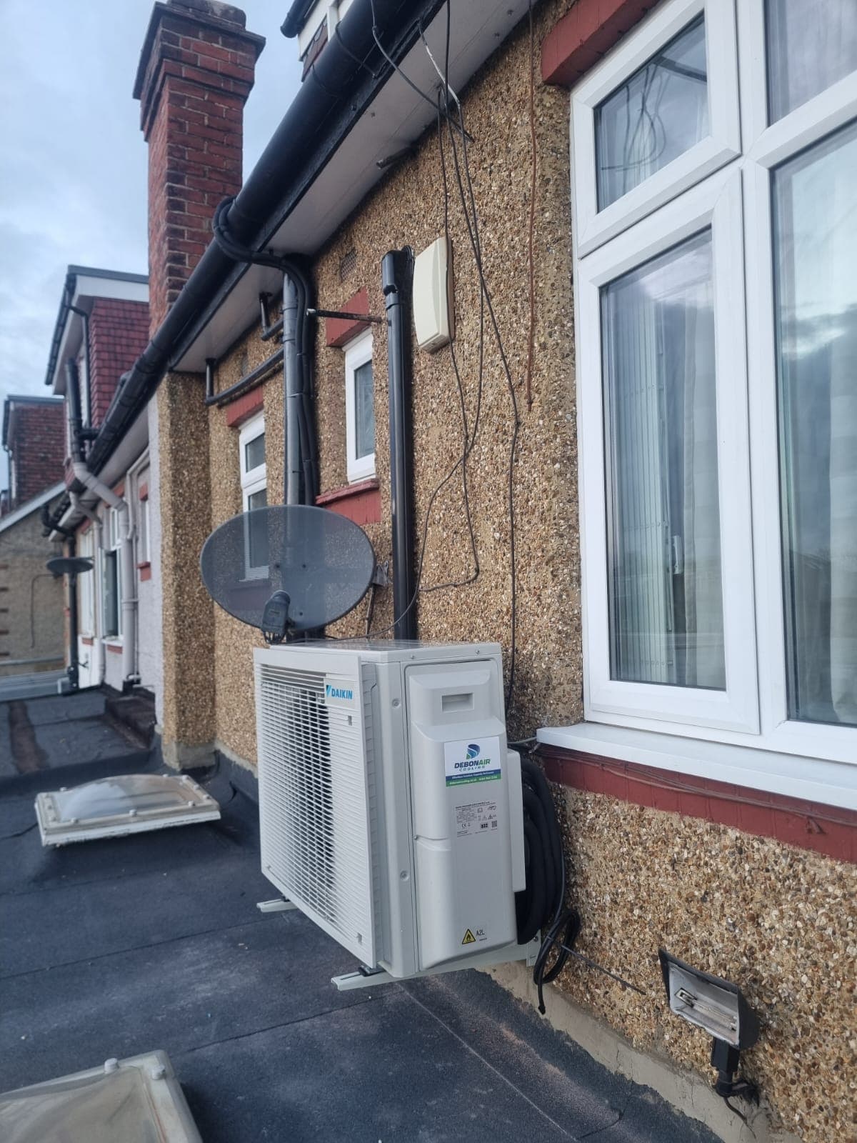 Outdoor AC condenser on a wall bracket - stone wall installation