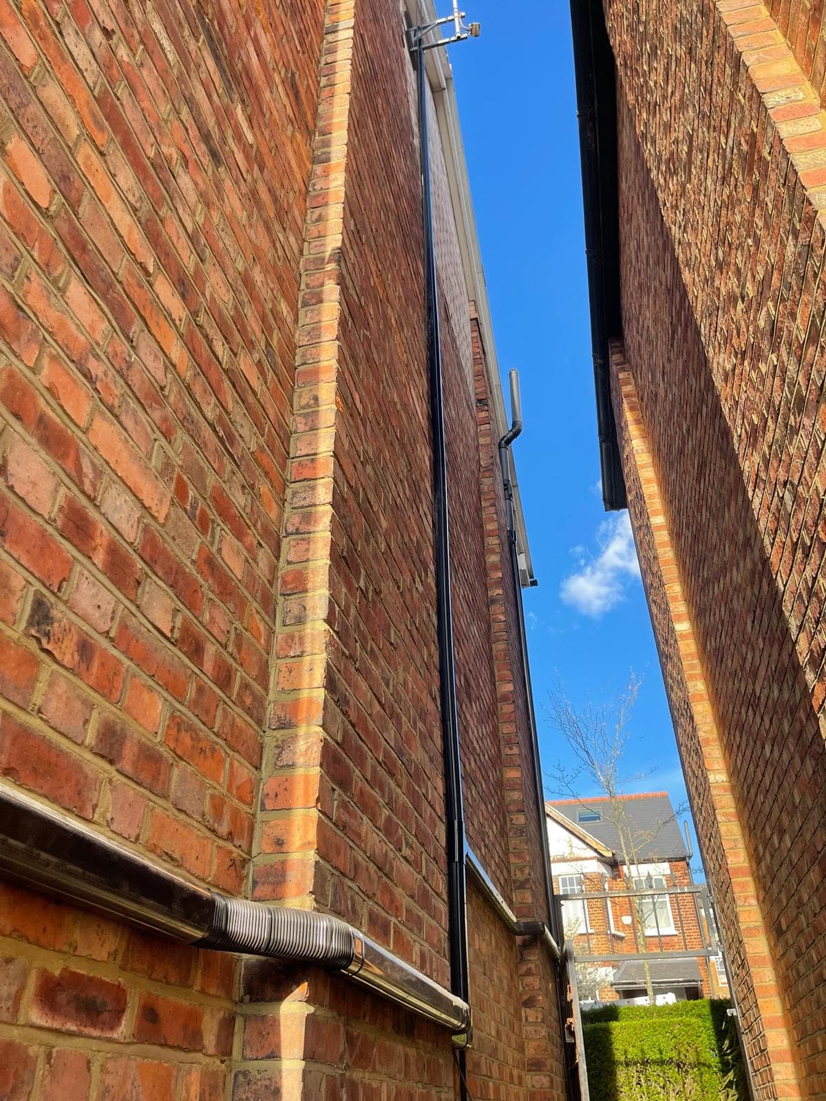 Black cable trunking run for a wall-mounted AC installation
