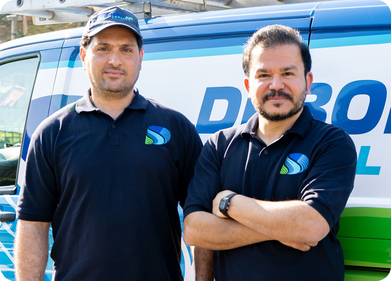 Two Debonair Cooling engineers in uniform, delivering a professional installation