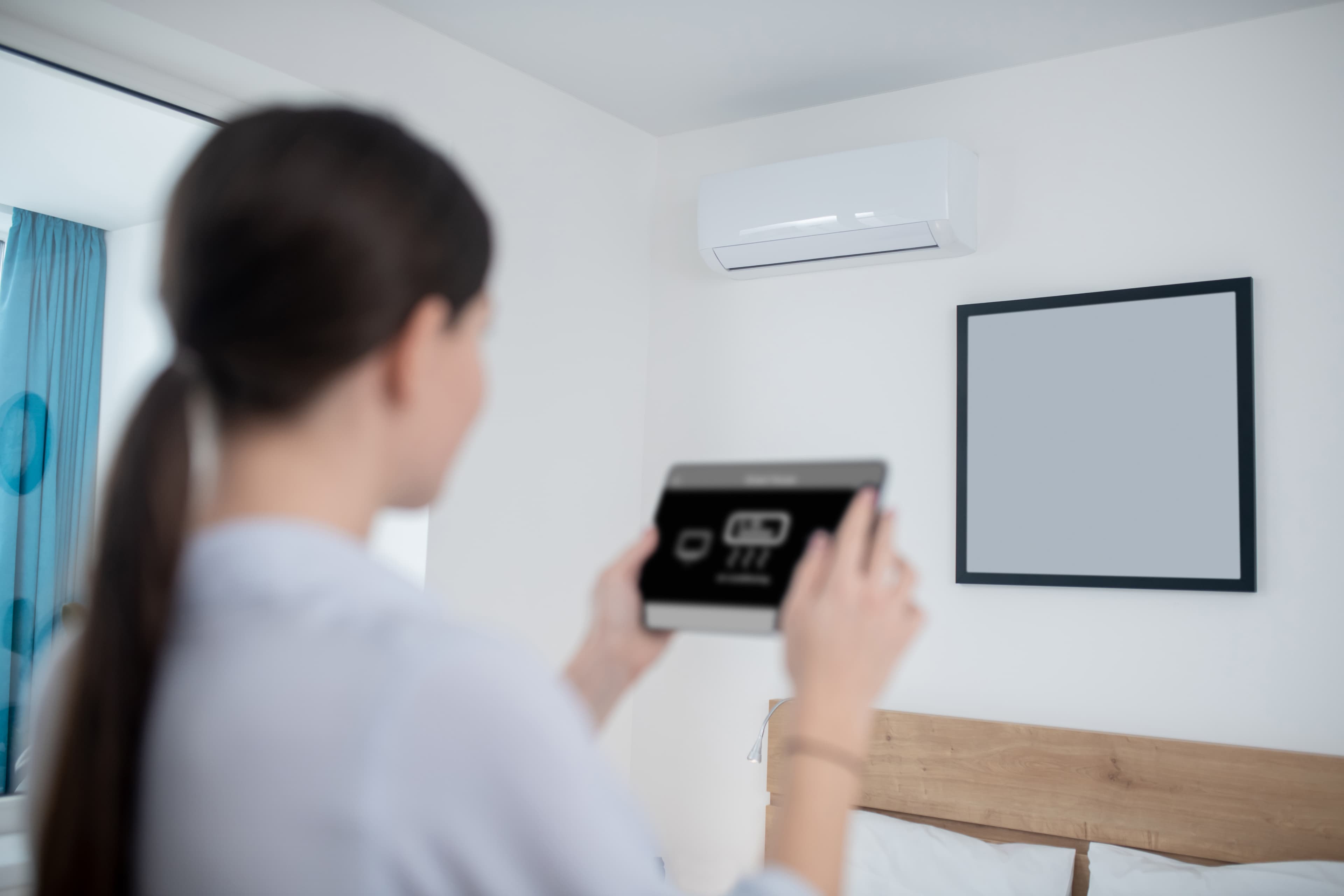 Customer using a wall-mounted controller during AC system handover