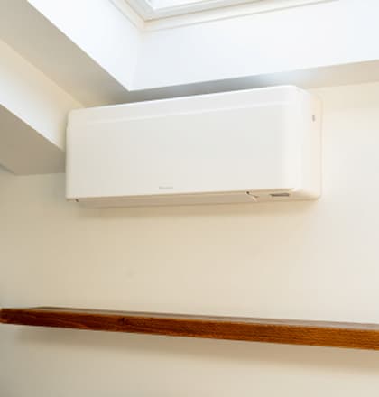 White Daikin air conditioning unit mounted on a cream wall